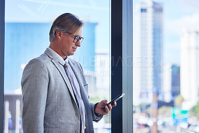 Buy stock photo Mature man, business and phone in office building for communication, networking and check schedule. Director, corporate and smartphone in workplace for investment, website or payment of travel flight