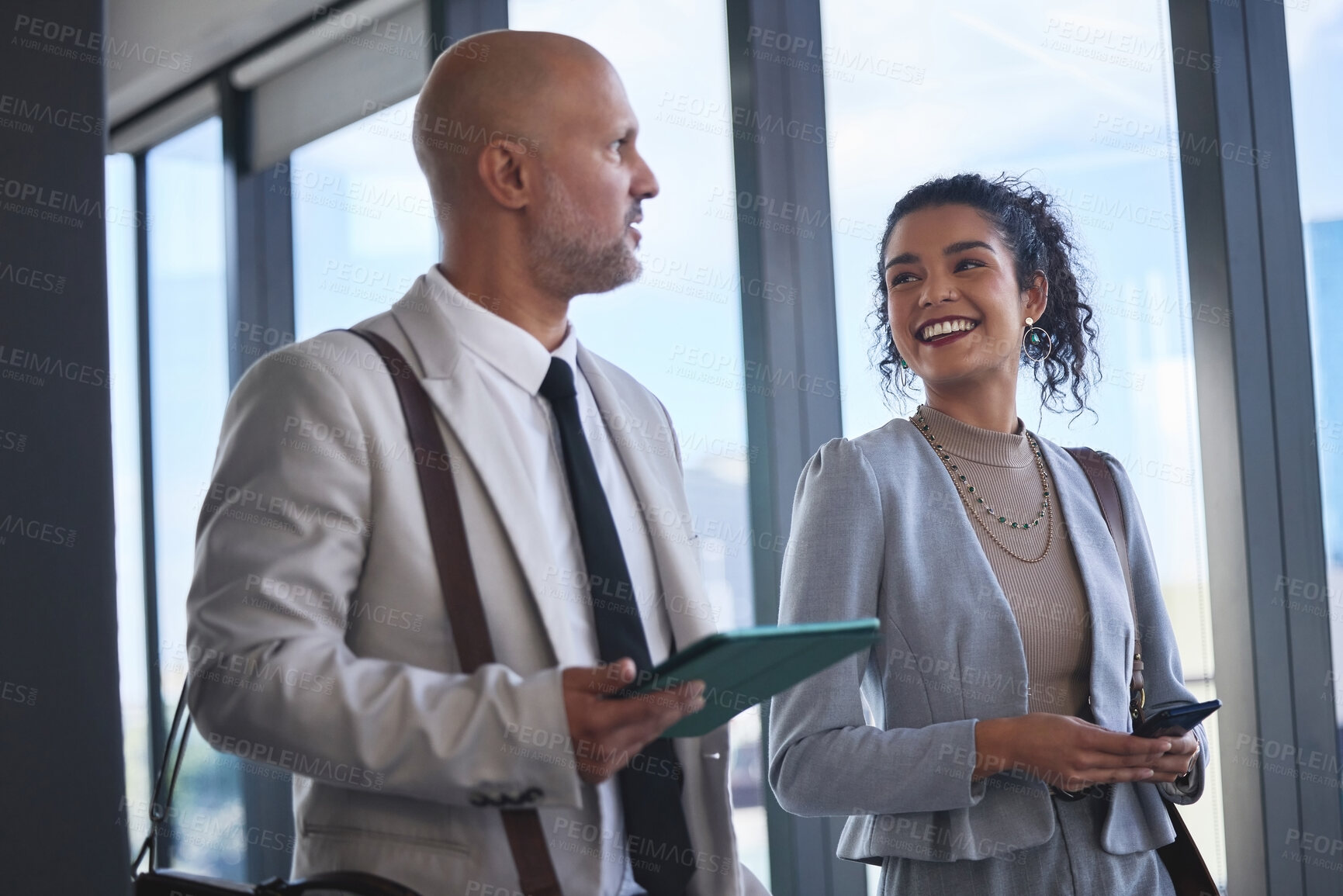 Buy stock photo Collaboration, technology and walking with business people in airport together for international travel. Conversation, phone or tablet with man and woman employee on bridge in terminal for flight