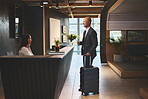 Service, reception and mature man with suitcase in hotel for business meeting, hospitality or check in. Travel, concierge woman and person with luggage for welcome, vacation or sales convention