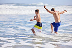 Father, boy and running at beach with waves, bonding or love in summer, vacation and together in nature. Dad, child and playful with care, holiday or people with family in sunshine by ocean in Spain
