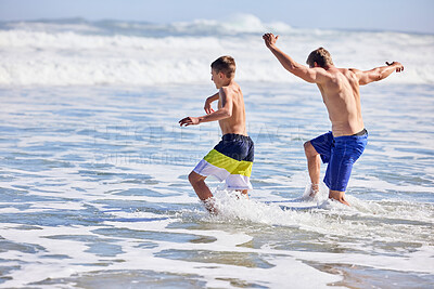 Buy stock photo Father, boy and running at beach with waves, bonding or love in summer, vacation and together in nature. Dad, child and playful with care, holiday or people with family in sunshine by ocean in Spain