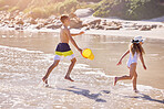 Kids, beach and playing with bucket in water with running for fun activity, summer holiday and freedom. Children, sibling and swimwear at sea with tropical adventure, family vacation and plastic toys