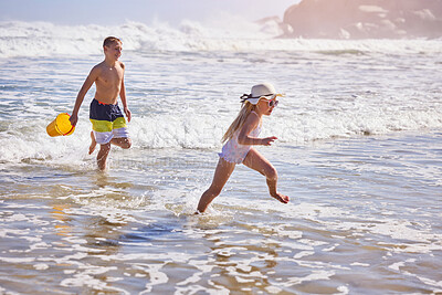 Buy stock photo Kids, beach and running with toys in water for playing with fun activity, summer holiday and freedom. Children, sibling and swimwear at sea with tropical adventure, family vacation and plastic bucket