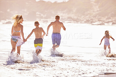 Buy stock photo Parents, children and splash in water at beach for vacation, love or summer for running together in nature. Dad, child and playful with back, holiday or people with family in sunshine by sea in Spain