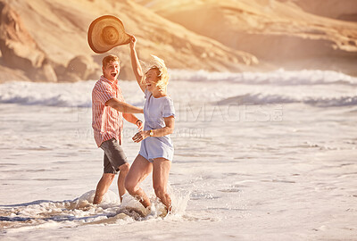 Buy stock photo Happy, beach and couple at sunset in waves for bonding, relax together and playful relationship by ocean. Dating, travel and man and woman with affection for romance on holiday, vacation and dance