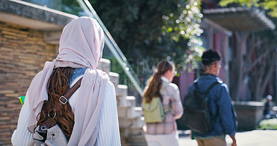 Buy stock photo University, students and woman in hijab walking from back with diversity, backpack and study in education. Culture, equality and Muslim college girl on campus for morning commute to school with group