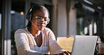 Typing, headphones and black woman with laptop, serious and listening to audio, video editing and glasses. Outdoor, freelancer and content creation at cafe, online and creative for post production