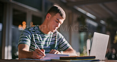 Buy stock photo Man, college student and outdoor with laptop or writing on notebook for assignment on campus. Male person, university learner and textbook for education with research or study for exam and assessment