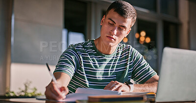 Buy stock photo Man, university student and campus with laptop or writing on notebook for assignment outdoor. Male person, college learner and textbook for education with research or study for exam and assessment