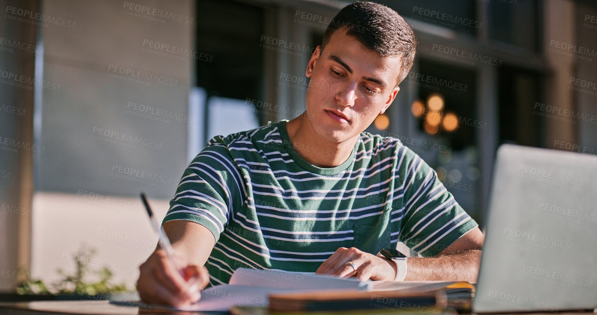 Buy stock photo Man, university student and campus with laptop or writing on notebook for assignment outdoor. Male person, college learner and textbook for education with research or study for exam and assessment