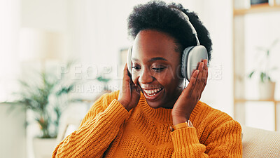 Buy stock photo Black woman, music and headphones in home for listening to audio, radio and hearing podcast on sofa. Happy african person relax for streaming sound, multimedia and online subscription in living room