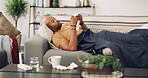 Living room, sick and man with tissue, sofa and allergies for sinus, season and sneezing with infection. Couch, blanket and symptoms with fever, runny nose and health of person with virus in house