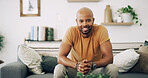 Man, portrait and smile in home with relax, weekend break and chill on sofa. African person, happy and stress free on living room couch for rest, good mood and enjoy me time in apartment lounge