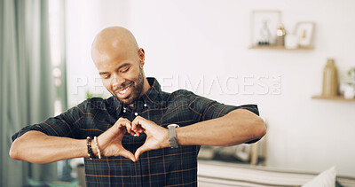 Buy stock photo Happy man, heart hands and love with emoji for emotion, care or romantic gesture at home. Male person, smile or like with sign, shape or icon for commitment, compassion or valentines day at house