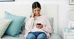 Woman, smartphone and happy with texting on sofa, chat or check notification in living room at in home. Person, smile and scroll with phone, mobile app and contact on social network at apartment