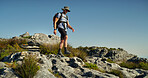 Hiking, mountain and walking with man in nature for fitness, travel adventure and workout. Space, backpacking and exercise with person outdoor on cliff for trekking holiday, explore and peace