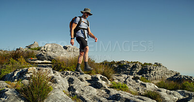 Buy stock photo Hiking, mountain and walking with man in nature for fitness, travel adventure and workout. Space, backpacking and exercise with person outdoor on cliff for trekking holiday, explore and peace