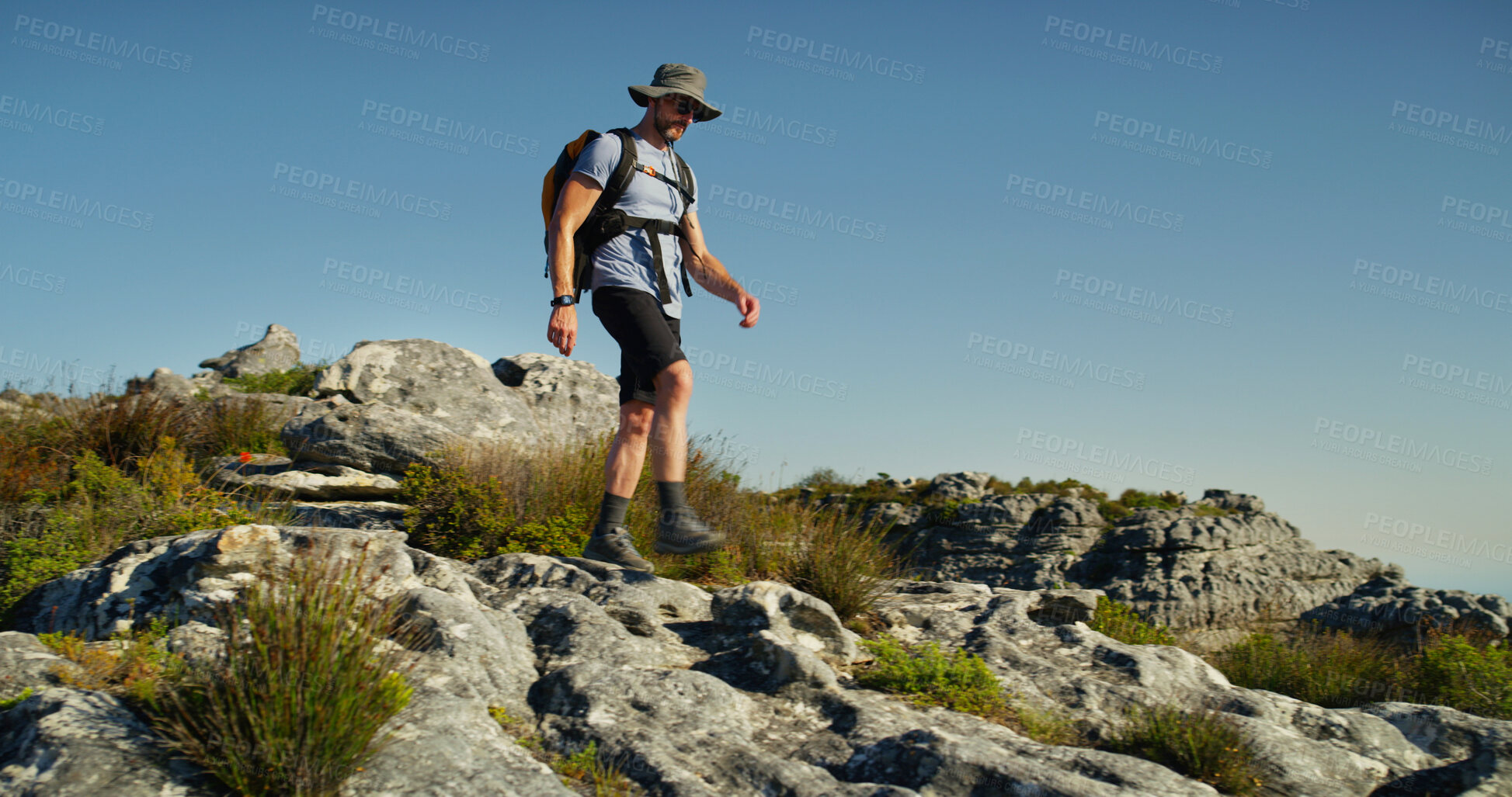 Buy stock photo Hiking, mountain and walking with man in nature for fitness, travel adventure and workout. Space, backpacking and exercise with person outdoor on cliff for trekking holiday, explore and peace