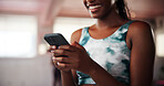 Hands, phone and texting at gym with fitness, contact or woman with smile for stats with wellness. Person, smartphone and app for progress, report and happy for results with workout at exercise club