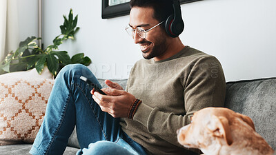 Buy stock photo Phone, dog and man with headphones on sofa for listening to radio, audio and music on weekend. Home, happy and person with pet on smartphone for social media, chat or streaming podcast in living room