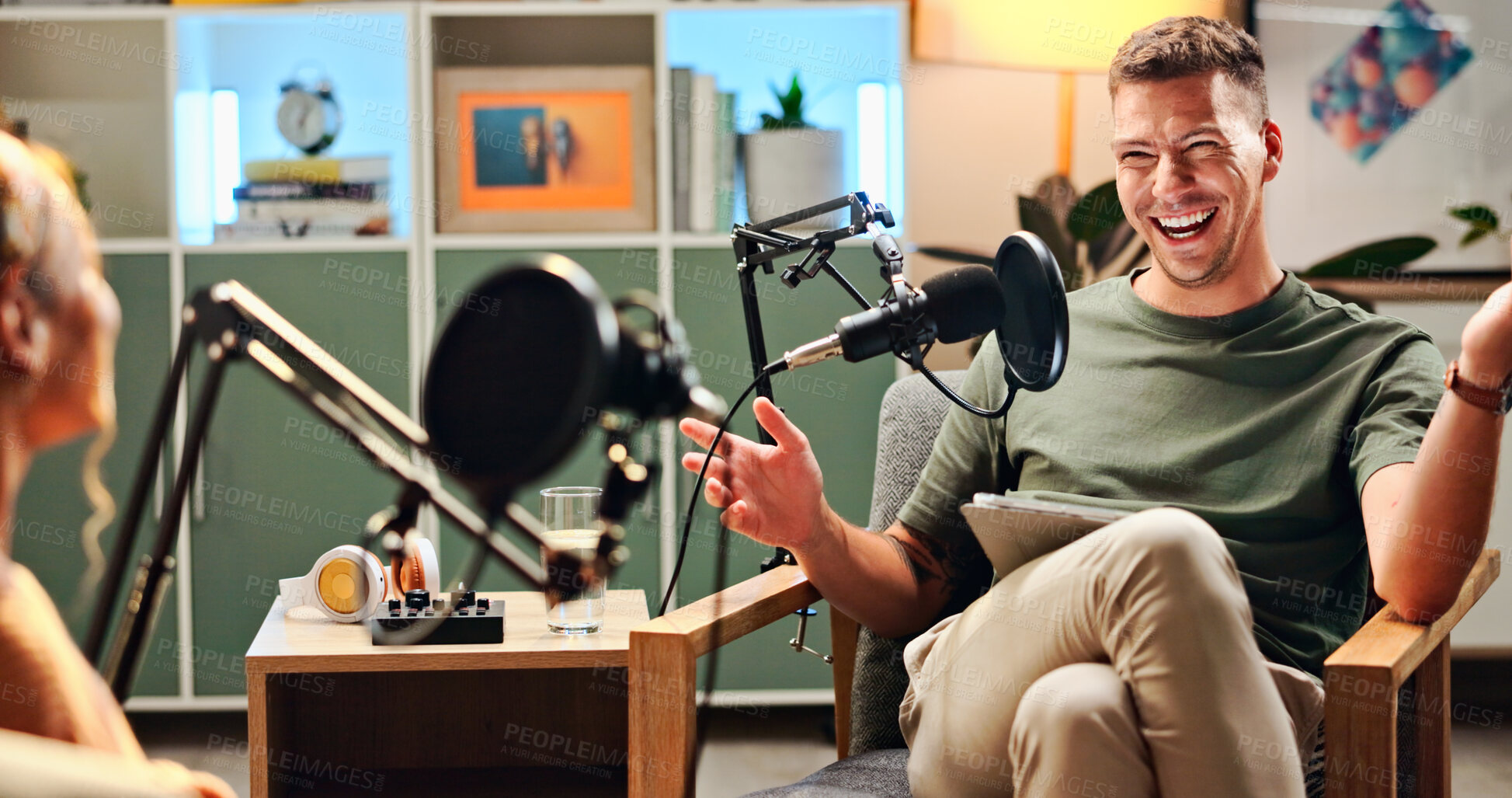 Buy stock photo Man, woman and podcast with mic, talking and home studio with smile for live streaming on social media. People, happy and interview with funny conversation, story and gossip with internet culture
