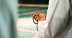 Muslim, hands and person with prayer beads in mosque, worship and remember of Allah with Quran recitation. Closeup, islamic man and praise with tasbih for faith, gratitude and spiritual in religion