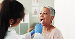 Clinic, woman and doctor with depressor for mouth, throat assessment and checkup for inflammation. Hospital, senior patient and otolaryngology with inspection for medical care, diagnosis and tongue