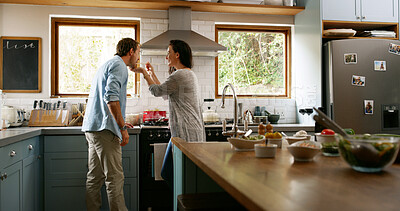 Buy stock photo Couple, cooking and taste food in kitchen at house for organic ingredients, meal prep and healthy lunch. Woman, feeding man and check with nutrition salad, vegan diet and romance for bonding together