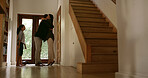 Hug, man and greeting family in home for welcome, affection and return from business trip. Child, mother and embrace dad by door for happy reunion, arrival and bonding together with goodbye and love