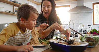 Buy stock photo Laughing, food and pasta with family at kitchen table for nutrition, bonding and health salad. Lunch, surprise and big appetite with mother and child eating at home for love, wellness and together