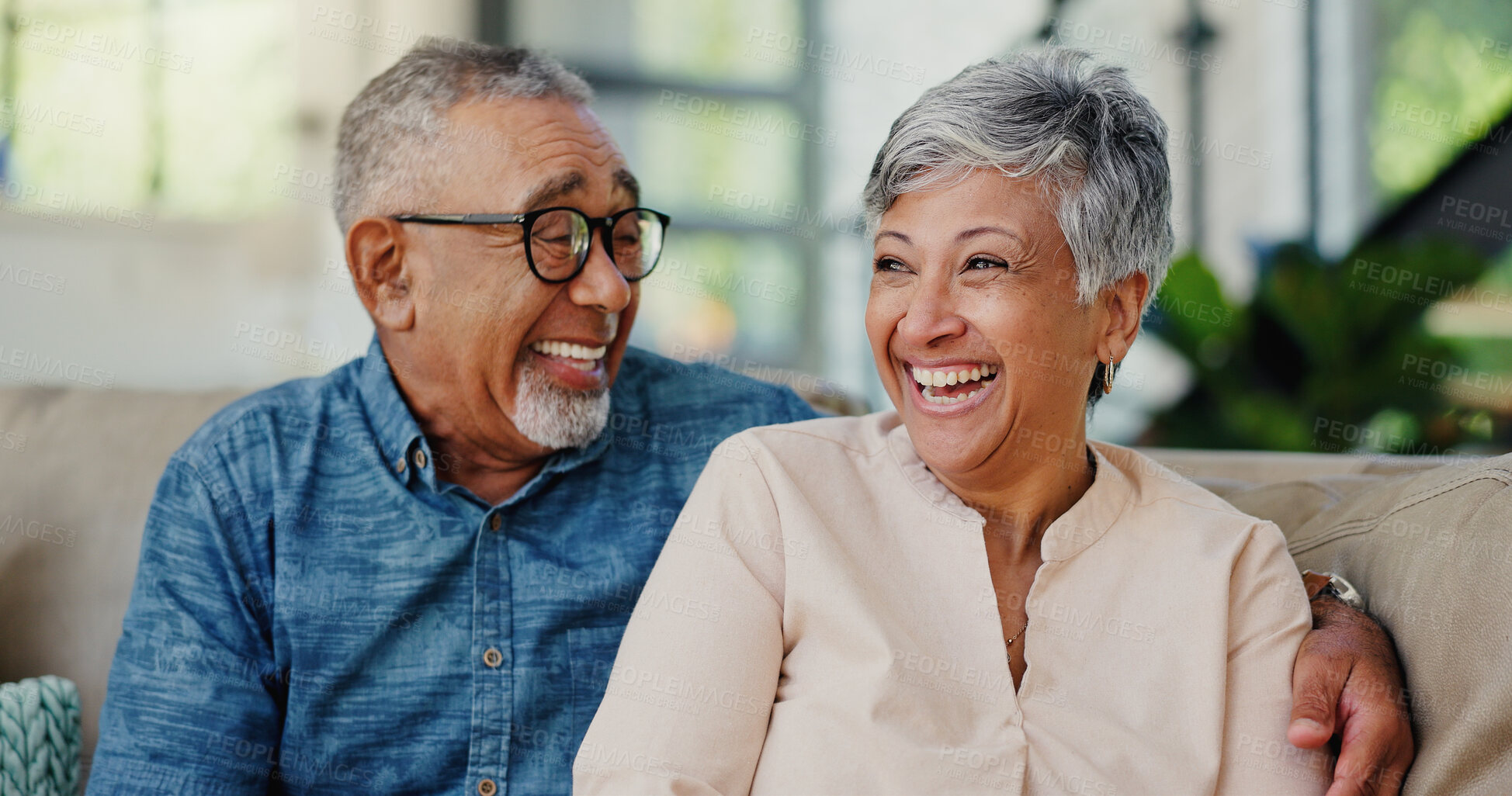 Buy stock photo Senior, couple and laughing with hug at house for funny joke, love and marriage commitment on couch. Smile, elderly people and embrace with support, care and relationship loyalty for retirement break