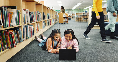 Buy stock photo Education, library and girls on floor, tablet and online learning with smile, knowledge and relax. Kids, students or friends on ground, tech or storytelling with ebook, break or bonding together