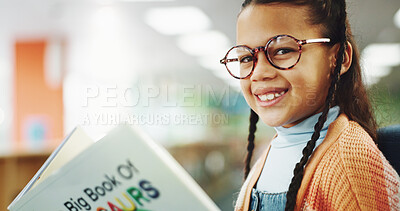 Buy stock photo Girl, child and portrait with reading book at library for education, learning or glasses for dinosaur story. School kid, happy and scholarship for language, knowledge and development at in Costa Rica