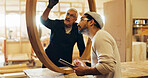 Carpenter, discussion and man with tablet in workshop for framework inspection, safety compliance or quality control. Manufacturing, people and team with structure evaluation and furniture production