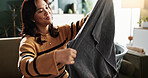 Cleaning, laundry and woman in home with housekeeping, service or hygiene in living room. Washing, serious and female person folding towel for housework or tidy on weekend for routine in apartment.