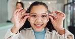 Optometry store, kid and shopping for glasses in optical shop with face, designer frame and spectacles fitting. Girl, customer and checking eyewear for lens choice, prescription size and healthcare