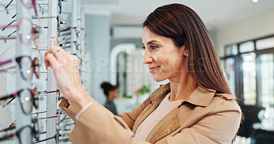 Buy stock photo Happy woman, customer and picking with glasses at store for optometry, eyewear or care at shop. Female person, frames and smile with spectacles for sight, vision or choice at optician or optometrist