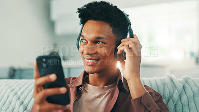 Buy stock photo Headphones, phone and man on sofa in living room listening to music, album or playlist for review. Happy, relax and male person with cellphone and audio tech for streaming app with podcast in home.