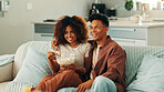 Popcorn, laughing or happy couple watching tv in home on sofa for funny movies, love or bonding together. Happy, subscription and man with woman or smile for streaming film, videos or comedy series