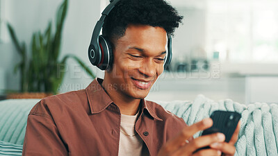 Buy stock photo Happy, man and phone with headphones on sofa for sound subscription, watching online video and social media. Relax, person and smartphone in home for streaming podcast or listening to music in lounge