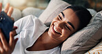 Woman, happy and relax with phone on sofa for weekend break, dating site chat or reading ebook. Smile, person and resting with smartphone in home for online subscription, social network or web scroll