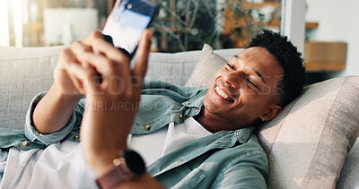 Buy stock photo Man, happy and relax with phone on sofa for weekend break, dating site chat or streaming service. Smile, person or resting with smartphone in home with online subscription, social media or web scroll