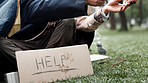 Hands, homeless and poverty with sign, drugs or deal for begging money, change or tent at park. Person, addiction and cardboard poster with bag, powder or narcotic substance abuse for habit on ground