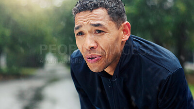 Buy stock photo Fitness, man and tired with breathing at park for running burnout, workout recovery and cardio challenge. Athlete, person and rest in rain with exercise break, exhausted and overworked with training