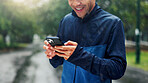 Nature, cellphone and hands of man with fitness routine on mobile app for outdoor training with workout. Phone, park and male athlete with cellphone for networking on cardio exercise in morning.
