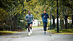 Workout, rain and men running in road for marathon training, endurance challenge and discipline with cardio exercise. People, teamwork and runner club with race, morning jog and wellness in nature