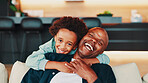 Portrait, hug and father with son, funny and bonding together with joke in living room. Face, African family or parent on sofa, dad or boy with happiness, embrace or home with humor, laugh or relax