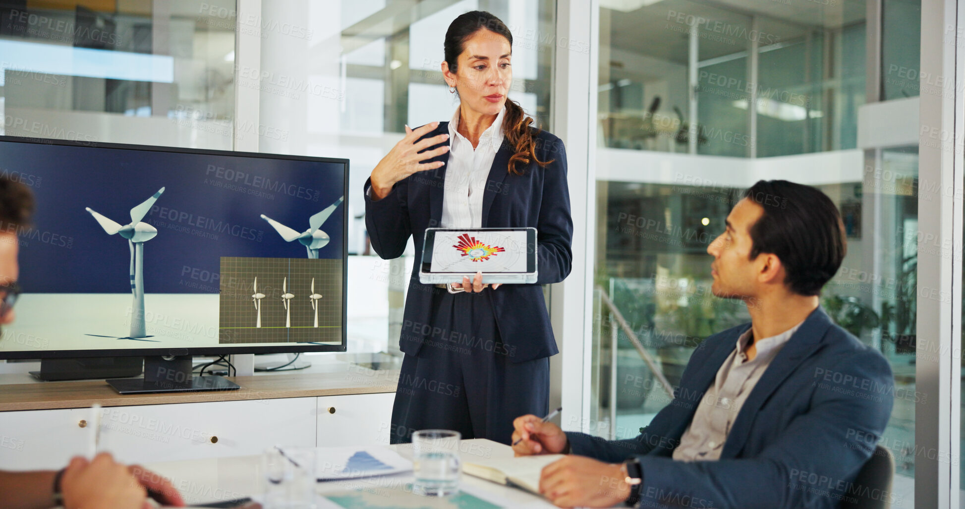 Buy stock photo Business people, screen and meeting with tablet for renewable energy, discussion or proposal at office. Female person, employee or speaker with technology display for wind turbine model or prototype
