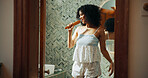 Woman, brush and singing with smile in bathroom for playful, concert and voice for sound and morning in home. African person, hair care and happy with karaoke, song and funny performance at apartment