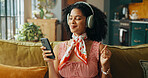 Mobile, music and woman dance on sofa, streaming sound and subscription for song in home. Headphones, phone and happy African person listening to radio, album and audio playlist on internet to relax